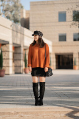Fashionable woman outdoor with orange sweater