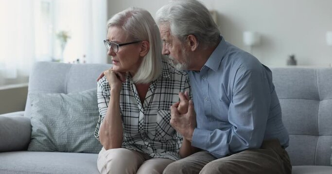 Concerned senior husband consoling frustrated desperate mature, consoling upset woman, holding hand, apologizing, giving help, support, comfort, empathy. Couple coping with problems