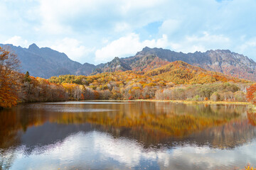 秋の紅葉の山と水面 長野県戸隠山と鏡池