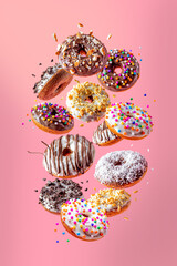 Donuts with sweet, flying on pink background.