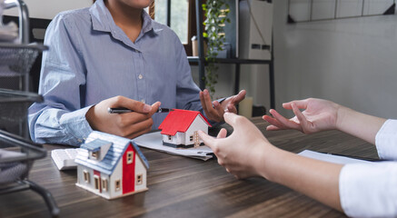 House model with agent and customer discussing for contract to buy, get insurance or loan real estate or property.