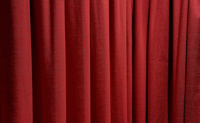 close up red curtains use as background. sack cloth texture drape for minimal interior design.  red natural linen drape curtains background. beautiful Christmas concept background.