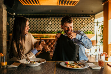 A diverse business pair, a man and a woman, at a restaurant, deciding what to order for lunch