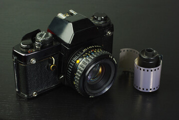 Old SLR film camera and film cassette.