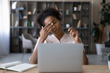 African gen Z student girl tired of studying at computer, touching irritable eyelids, face with...