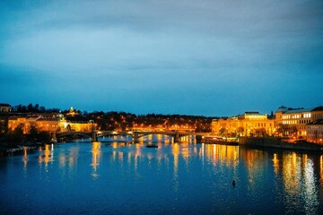 Fototapeta na wymiar Winter twilight in Prague, snow, no one, lights on, Charles Bridge