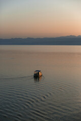 Boat sailing towards the sunset on Lake Ohrid