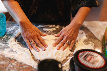 Close up of a woman's hand working on a home made pizza dough