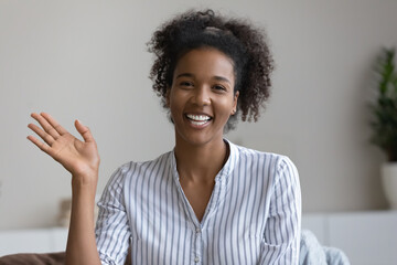 Happy millennial Black girl, young woman waving hello at webcam, smiling at camera, making video call from home, greeting and talking at online conference. Screen view, head shot portrait - obrazy, fototapety, plakaty