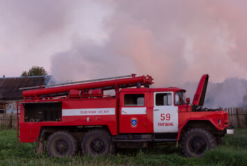 Fire service officers arrived at the scene. A fire truck at the scene of the fire. A fire in the village. Burning wooden houses in the village of Rantsevo, Tver region.