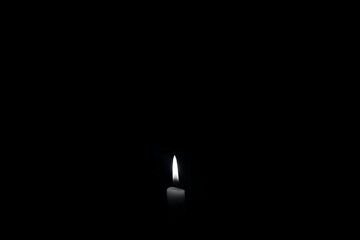 burning candle on black background