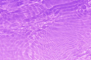 Purple water bubbles with ripples on the surface. Transparent pink colored clear calm water surface texture with splashes and bubbles. Water waves with shining pattern texture background.