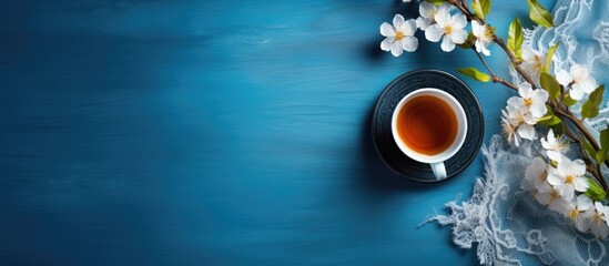 Obraz na płótnie Canvas Tea served in a cup placed on a background of blue with accompanying floral patterns and fabric