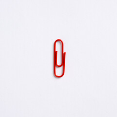 Obraz premium Red paper clip on white background with copy space.