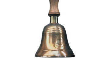 Old ship hand bell made of yellow metal with an anchor pattern, isolated on a white background