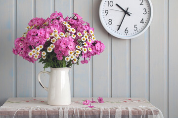 summer still life with garden phlox and daisies indoors.