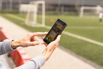 betting bet sport phone gamble over shoulder soccer live website concept. - obrazy, fototapety, plakaty