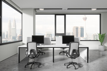 Light workplace interior with pc computers and table near panoramic window