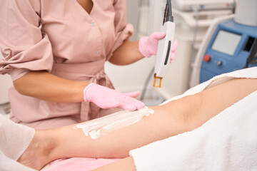Specialist lubricates the patients legs with a protective cream
