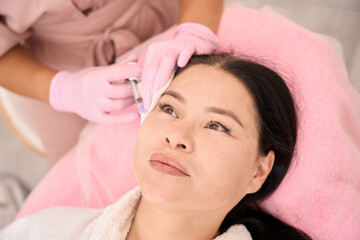 Esthetician gives beauty injections to a woman