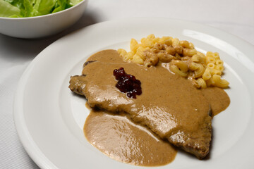 Beef Escalope or Rindsschnitzel with Sour Cream Sauce, Pasta and Cranberry Preserve Austrian Style