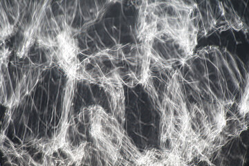 Glare from light, abstract white stripes on blurry dark background