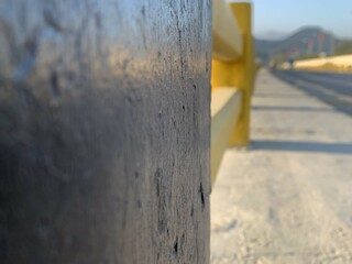 Concrete bridge painted yellow and black close-up, traveling road