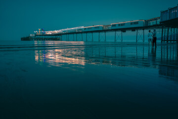 Obraz premium A night time shot of a pier in the calm sea