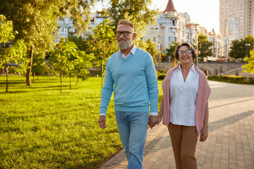 Happy senior couple tourist walking among public park on excision