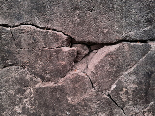 Grungy wall of gray concrete texture with cracked surface from sand and cement materials.