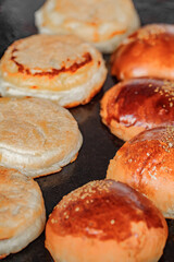 Round buns for burgers fried on baking sheet, close-up, selective focus