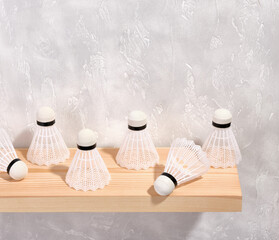 Badminton white shuttlecocks on a wooden shelf. Copy space for text. Composition of sport game.