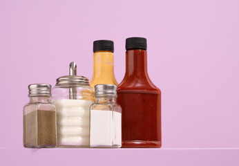 Delicious dinner and mustard, ketchup on table. Salt, sugar and pepper.