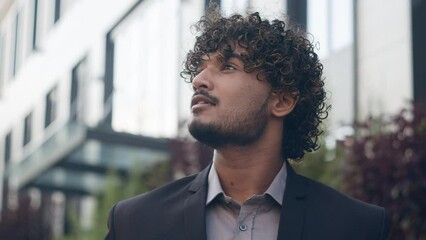 Close-up ethnic Indian Arabian male inspired business man dreaming entrepreneur outdoors looking at distance thinking contemplate. Portrait Hispanic businessman pensive guy employer in city background
