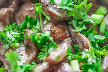Mushrooms champignons stewed in sour cream sauce with green parsley, close-up, selective focus