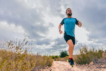 Middle-aged man running in nature with copy space