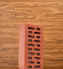 Facing orange brick for building a house on a wooden background.