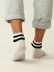 white socks with black stripes with copy space on human foot closeup photo on white background