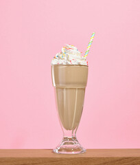 Birthday yummy sweet cream milkshake in a glass with colored sprinkles and straw. Wonderful holiday.