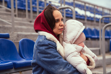 A young mother and her newborn daughter at the stadium