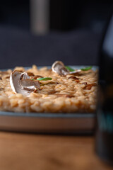 Obraz na płótnie Canvas Dish of risotto with porcini mushrooms on grey plane