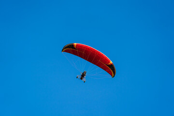 Flying with paramotor in the blue sky - Man riding paramotor in the blue sky background