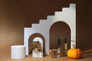 Autumn presentation for product. Geometric figures, golden leaf and pumpkin on brown background