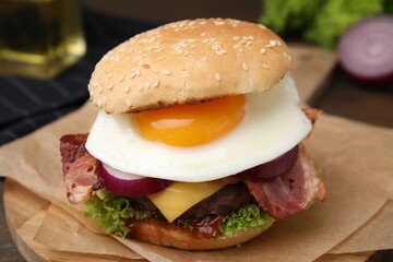 Delicious burger with fried egg on table, closeup