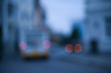 evening city street in the light of headlights and lanterns blur background