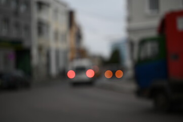 evening city street in the light of headlights and lanterns blur background