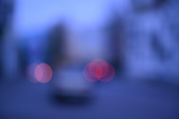 evening city street in the light of headlights and lanterns blur background