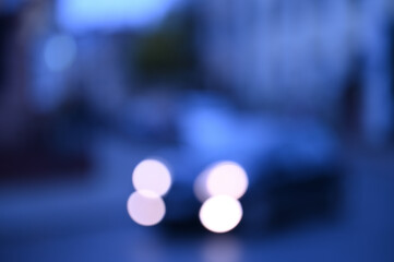 evening city street in the light of headlights and lanterns blur background
