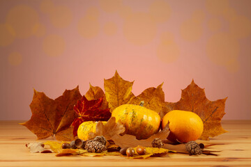 Autumn still life with pumpkins, leaves and acorns on wooden table