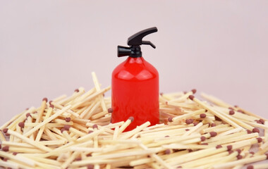 A box of matches placed next to a toy red fire extinguisher against a light background.